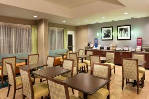 a restaurant with tables and chairs and a bar at Hampton Inn Denville-Rockaway-Parsippany in Denville