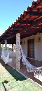 une maison avec un hamac sur la terrasse couverte dans l'établissement Pousada Estância Mineira, à Guapé