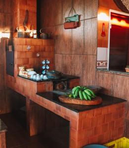una cocina con un montón de plátanos en una barra en Pousada Estância Mineira en Guapé