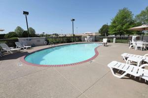 a large swimming pool with white chairs and tables at Hampton Inn Dyersburg in Dyersburg