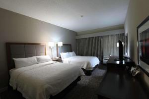 a hotel room with two beds and a television at Hampton Inn Dyersburg in Dyersburg