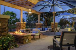 a patio with a fire pit with chairs and umbrellas at Hampton Inn Edenton in Edenton