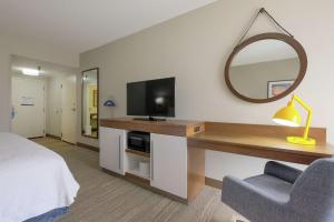 a bedroom with a desk with a television and a mirror at Hampton Inn Edenton in Edenton