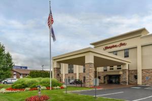 a building with an american flag in front of it at Hampton Inn Elkhart in Elkhart