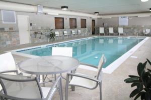 a large pool with a table and chairs and a table and a table and chairs at Hampton Inn & Suites Radcliff/Fort Knox in Radcliff