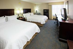 a hotel room with two beds and a flat screen tv at Hampton Inn Elizabethtown in Elizabethtown
