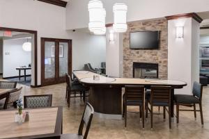 a room with a bar with chairs and a fireplace at Homewood Suites by Hilton El Paso Airport in El Paso