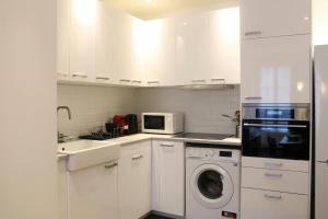 una cucina bianca con lavatrice e forno a microonde di Cosy 28 m love nest in Saint-Denis a Saint-Denis