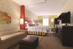 エリーにあるHome2 Suites by Hilton Erieのベッドとソファ付きのホテルルーム