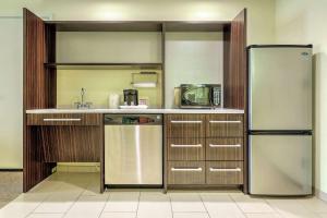 a kitchen with a refrigerator and a sink at Home2 Suites by Hilton Erie in Erie