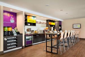a restaurant with a bar with a table and chairs at Home2 Suites by Hilton Rahway in Rahway