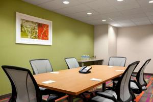 Home2 Suites by Hilton Rahway في راواي: قاعة اجتماعات مع طاولة وكراسي خشبية