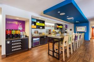 a restaurant with a counter and a bar with chairs at Home2 Suites by Hilton Fargo in Fargo