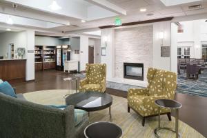 vestíbulo con sillas, mesa y chimenea en Homewood Suites by Hilton Fresno Airport/Clovis, en Clovis