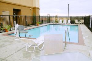 a swimming pool with two lawn chairs at Hampton Inn & Suites Madera in Madera