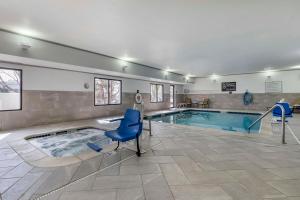 een groot zwembad met een blauwe stoel in een kamer bij Hampton Inn Fort Collins in Fort Collins