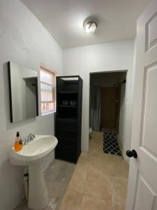 baño con lavabo y armario negro en Hostal Font´s en Areponapuchi