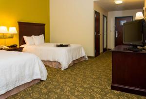 a hotel room with two beds and a flat screen tv at Hampton Inn Frankfort in Frankfort