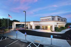 Hampton Inn Sierra Vista في سييرا فيستا: واجهة متجر مع علم أمريكي في موقف للسيارات