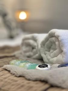 a towel on a bed with a toothbrush and a bottle at Beautiful Apartment in Camden Town in London