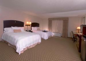 a hotel room with two beds and a television at Hampton Inn & Suites Farmington in Farmington