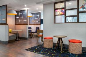 a lobby with two tables and chairs and windows at Hampton Inn Commercial Boulevard-Fort Lauderdale in Tamarac