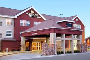 un hotel con un edificio rojo con un cartel en él en Homewood Suites by Hilton Sioux Falls, en Sioux Falls