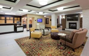 a lobby with chairs and a living room with a fireplace at Homewood Suites by Hilton Sioux Falls in Sioux Falls