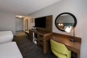 a hotel room with a bed and a mirror at Hampton Inn and Suites Fredericksburg in Fredericksburg
