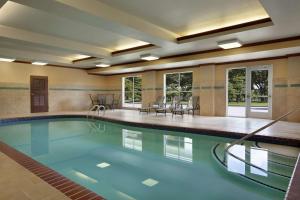 a swimming pool with blue water in a building at Homewood Suites by Hilton Fort Smith in Massard