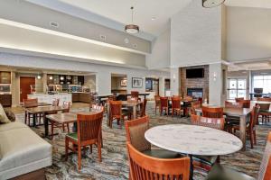 a restaurant with tables and chairs and a bar at Homewood Suites Fredericksburg in Fredericksburg