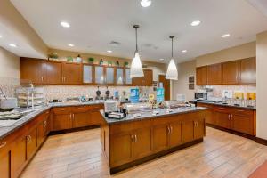 a large kitchen with wooden cabinets and wooden floors at Homewood Suites by Hilton Fort Worth Medical Center in Fort Worth