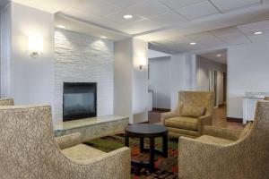 uma sala de espera com cadeiras, uma televisão e uma mesa em Homewood Suites by Hilton Ft. Worth-North at Fossil Creek em Fort Worth