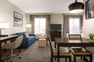 a living room with a blue couch and a table at Homewood Suites Fort Wayne in Fort Wayne