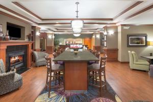 uma ampla sala de estar com lareira, mesa e cadeiras em Hampton Inn Siloam Springs em Siloam Springs