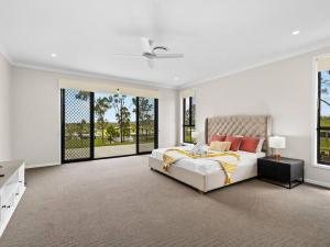 um quarto branco com uma cama e janelas grandes em The BlissNest - Jimboomba em Jimboomba