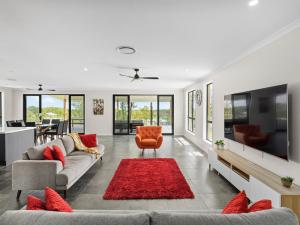 uma sala de estar com dois sofás e um tapete vermelho em The BlissNest - Jimboomba em Jimboomba