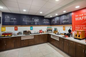 a kitchen with wooden cabinets and a sign on the wall at Hampton Inn Gadsden in Gadsden