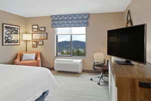 スポケーン・バレーにあるHampton Inn & Suites Spokane Valleyのベッド1台、薄型テレビが備わるホテルルームです。