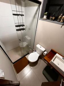 a bathroom with a toilet and a shower and a sink at Casa Container Camisão 