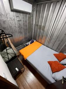 a small room with a bed and a chair at Casa Container Camisão 