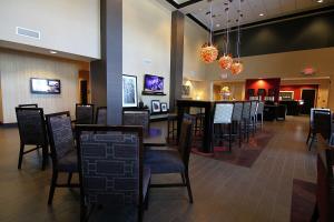 a restaurant with chairs and tables and a bar at Hampton Inn & Suites Grand Forks in Grand Forks