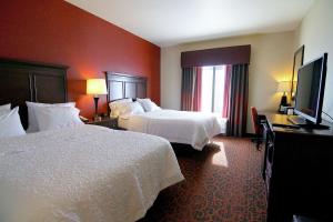 Habitación de hotel con 2 camas y TV de pantalla plana. en Hampton Inn & Suites Grand Forks, en Grand Forks