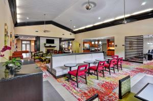 a lobby with red chairs and tables on a rug at Homewood Suites by Hilton- Longview in Longview