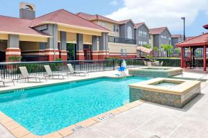 una piscina in un complesso di appartamenti con sedie intorno di Homewood Suites by Hilton- Longview a Longview