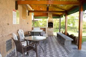 d'une terrasse avec une table, des chaises et une cheminée. dans l'établissement Conforto & tranquilidade, à Rio das Ostras