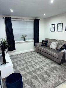 a living room with a couch and a window at Blue Madison in Aldershot