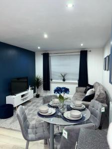 uma sala de estar com uma mesa e um sofá em Blue Madison em Aldershot