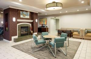 a waiting room with a fireplace and a table and chairs at Homewood Suites by Hilton Gainesville in Gainesville