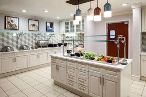 a large kitchen with white cabinets and a sink at Homewood Suites by Hilton Gainesville in Gainesville